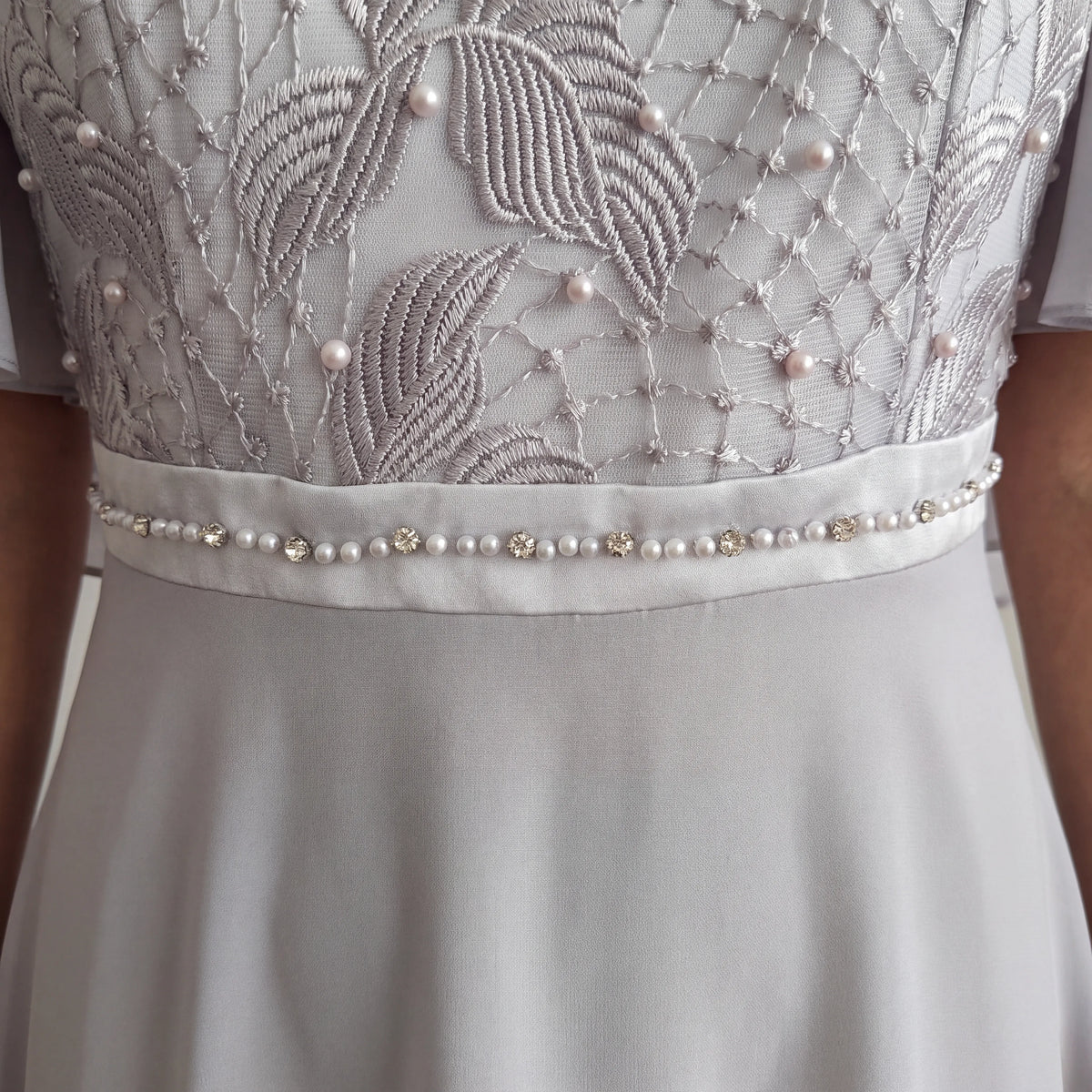Close-up of the silver Lizabella 2344 Mother of the Bride dress showing the embellished waistband and delicate fabric detailing.