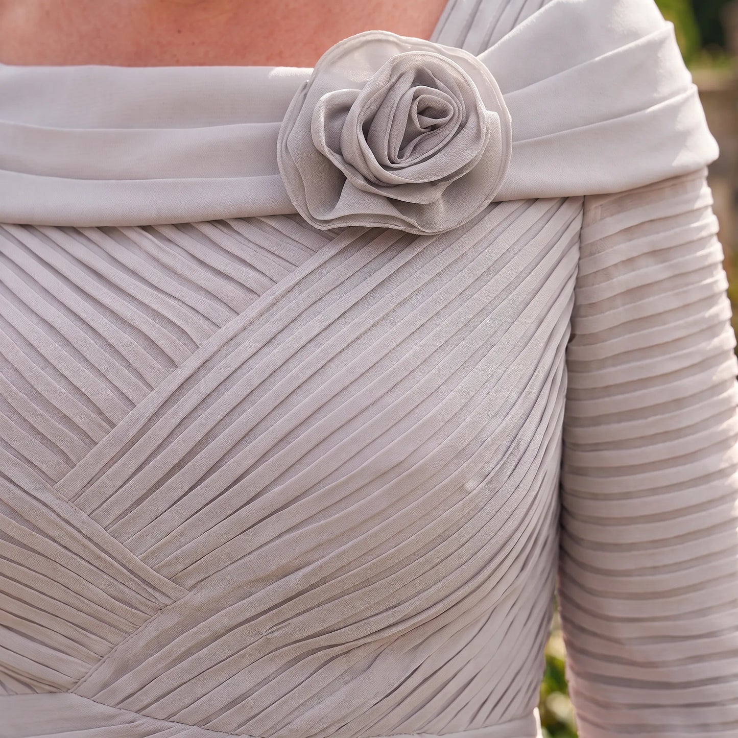 Close-up of the Couture Club 5G114 Silver Mother of the Bride dress highlighting the floral neckline, ruched bodice and pleated detailing.