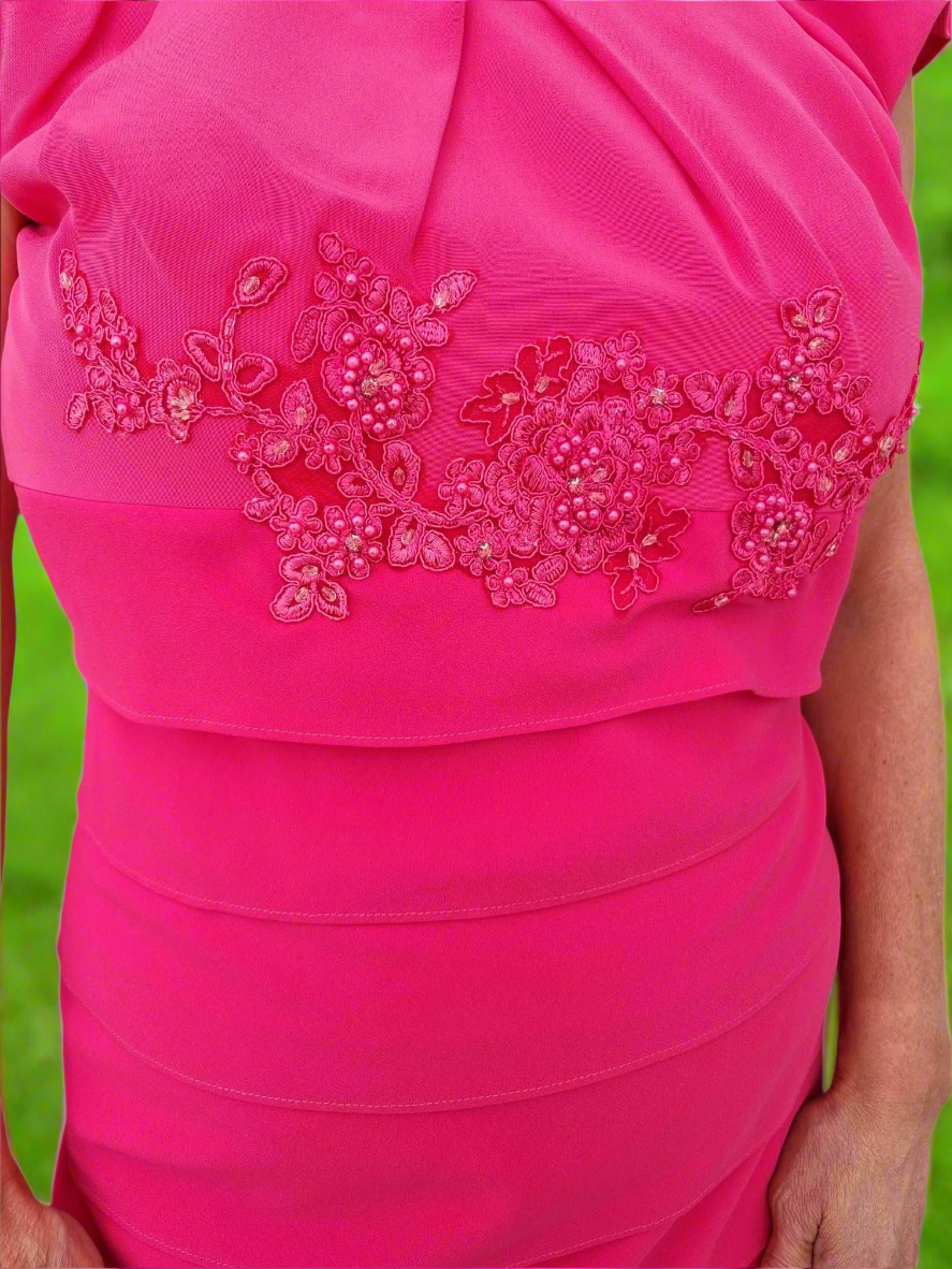 Pink dress with floral embroidery on a white background